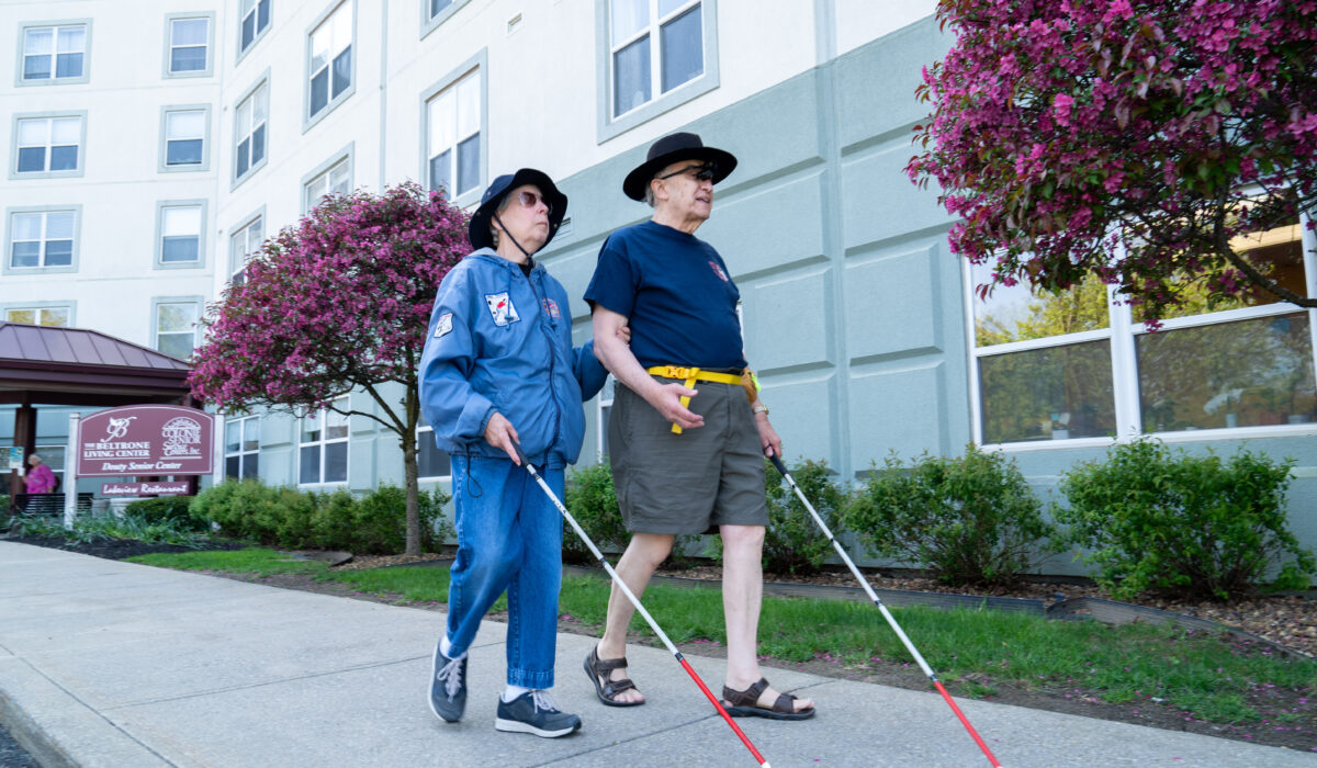 Couple walks together with white canes